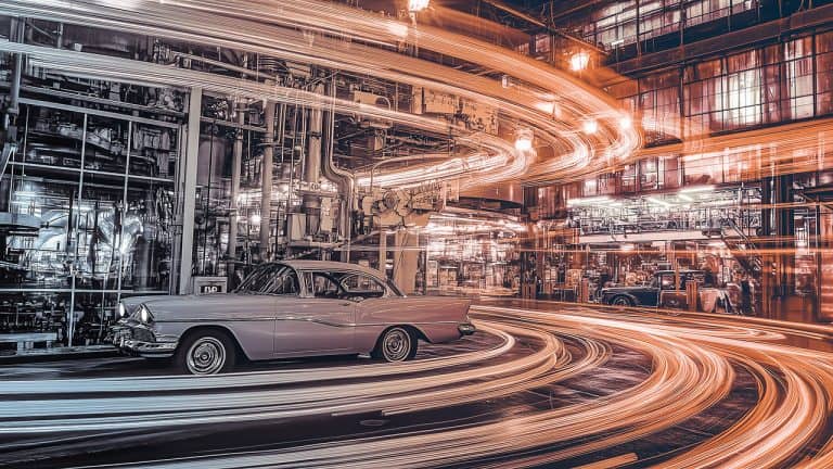 Double exposure of a vintage car in a factory setting and swirling red light trails: motion and nostalgia concept.