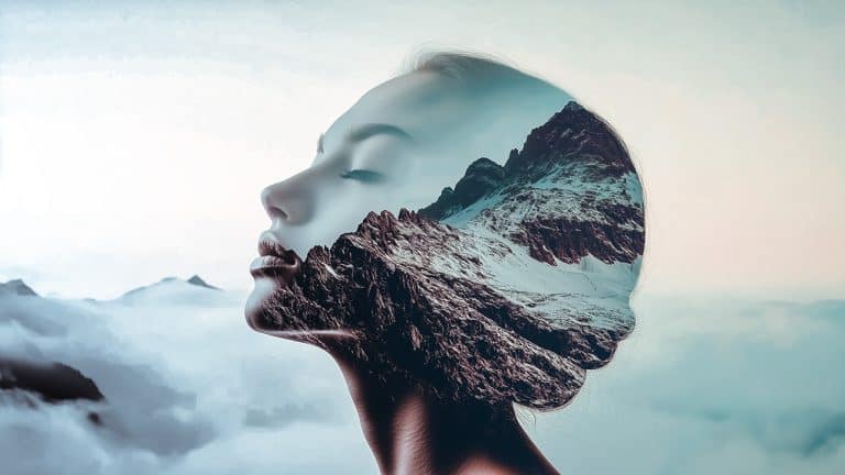 Double exposure of a serene woman's profile with closed eyes and a rugged mountain landscape: harmony with nature concept.