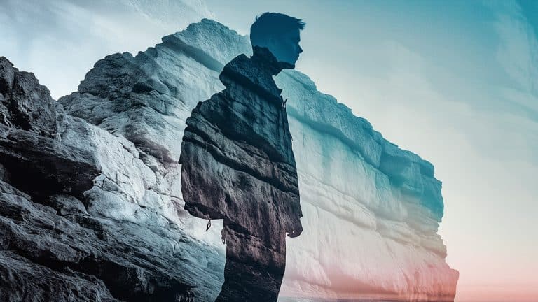 Double exposure of a silhouette of a person in profile and a rocky mountain landscape: exploration and introspection concept.