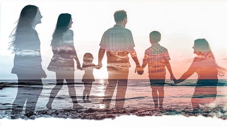 Double exposure of a family holding hands walking along a beach