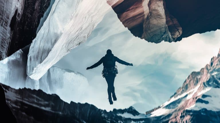 Double exposure of a person in climbing gear suspended in mid-air and a rugged mountain landscape with glaciers: adventure and exploration concept.