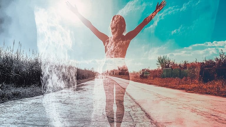 Double exposure of a woman with arms outstretched and a rural road under a bright sky: freedom and openness concept.