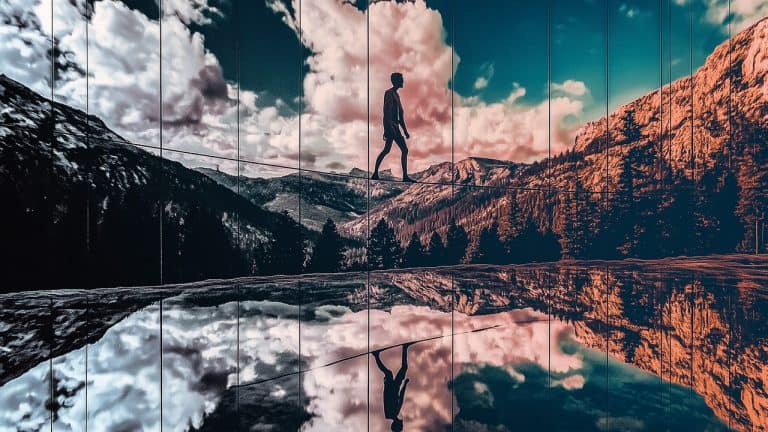 Double exposure of a silhouette of a person walking on a tightrope and a mountainous landscape with clouds and trees reflected on glass: balance and reflection concept.