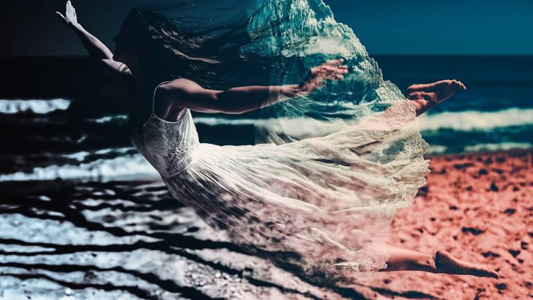 Double exposure of a woman in a white dress appearing to fly over a beach