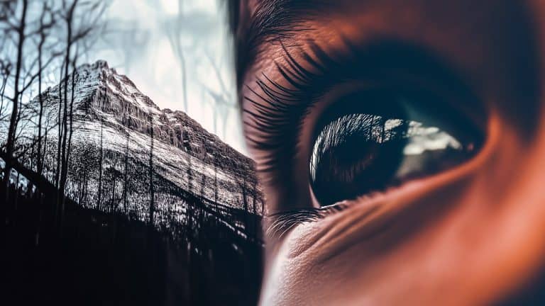Double exposure of a close-up human eye reflecting a landscape