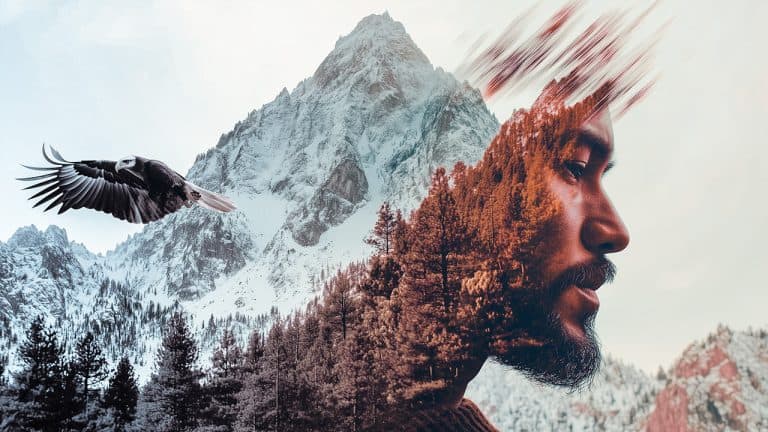 Double exposure of an eagle soaring over a snowy mountain and the profile of a man blended with an autumn forest: freedom and introspection concept.