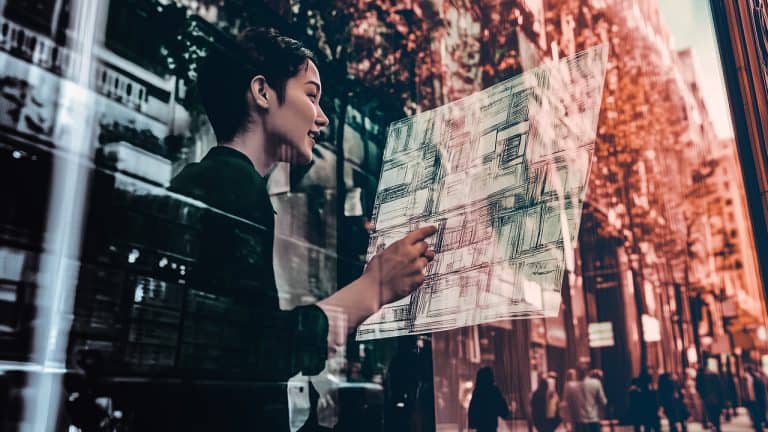 Double exposure of a woman pointing at architectural plans on glass and a busy city street with building reflections: urban planning and innovation concept.