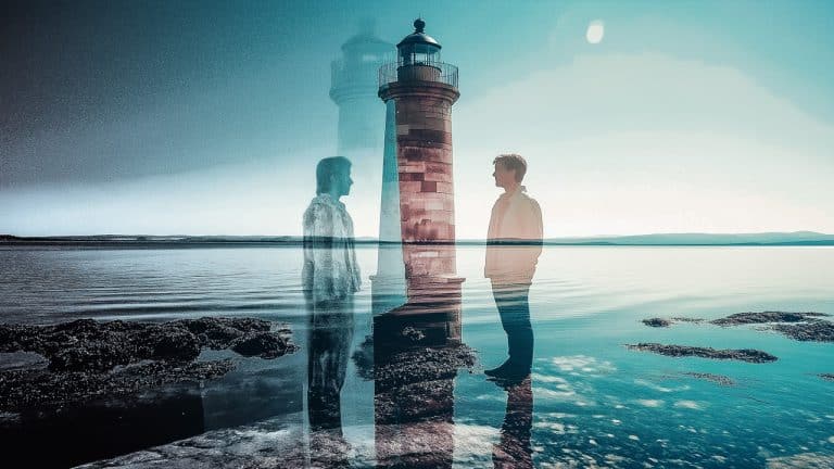 Double exposure of a silhouette of a person standing on a rocky shore and a lighthouse against a clear sky: reflection and solitude concept.